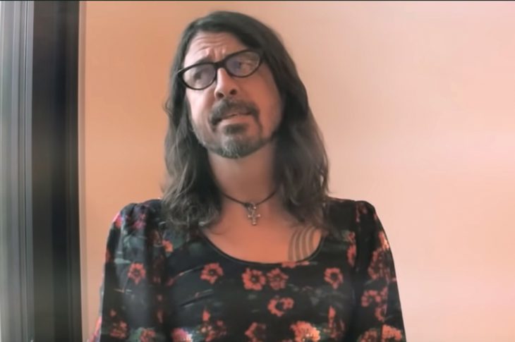 Dave Grohl dressed as Lisa Loeb standing at a window