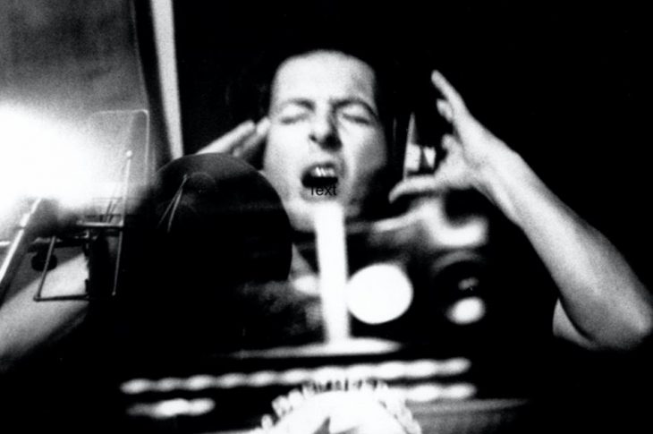 black and white photo of Joe Strummer singing in a recording studio