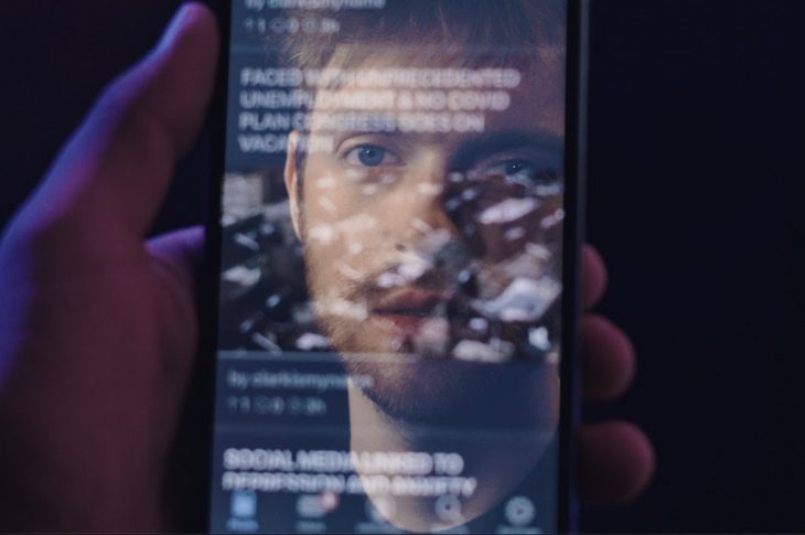Artist's face reflected in a phone screen.