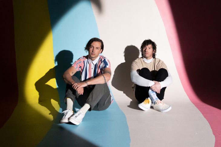 Picture of Josh Dun and Tyler Joseph sitting in a room of colorful stripes.