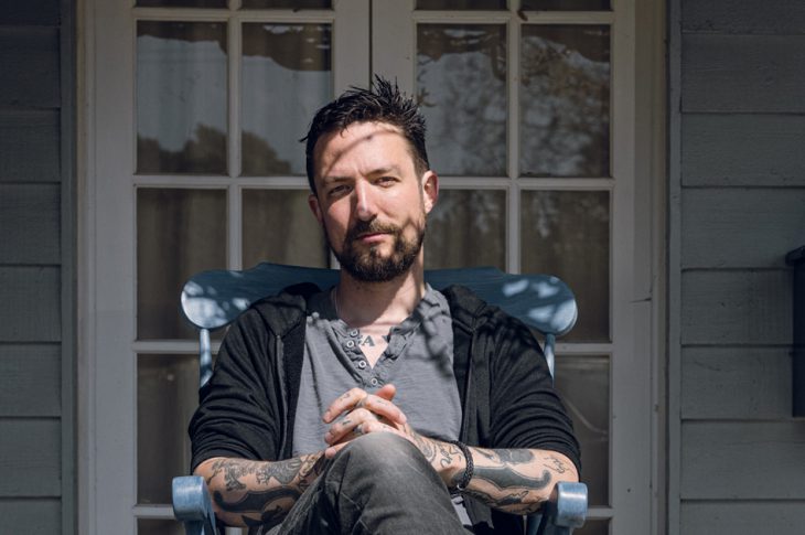 photo of Frank Turner sitting in rocking chair on porch