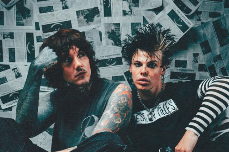 Oli Sykes and Yungblud photographed in front of newspaper clippings