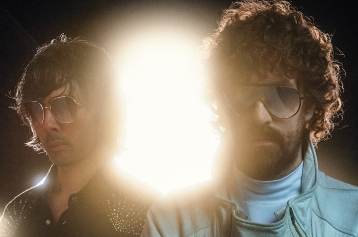 Members of electronic duo Justice with bright light shining from behind.