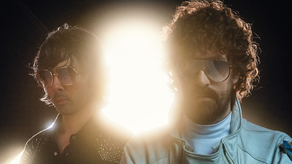 Members of electronic duo Justice with bright light shining from behind.