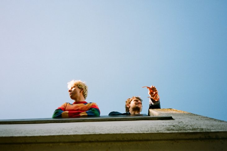 Photo looking up at band members on rooftop