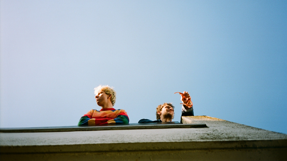 Photo looking up at band members on rooftop