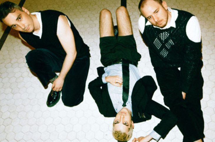 three people sitting on the floor, looking up at camera