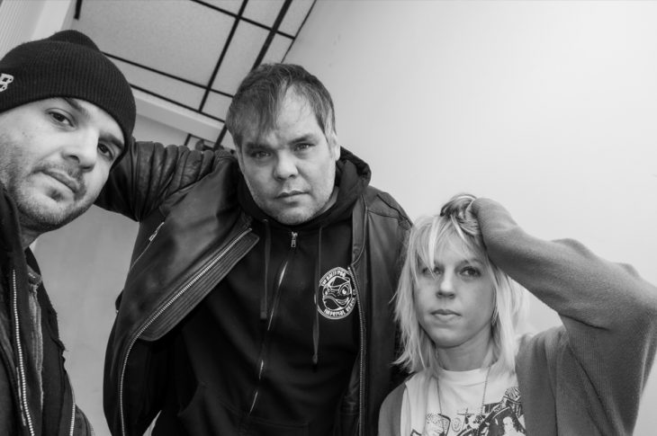 Three people photographed in stairwell