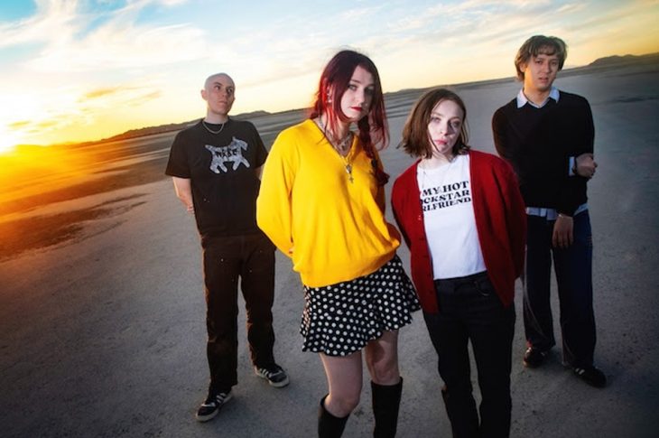 Four people photographed outside during sunset