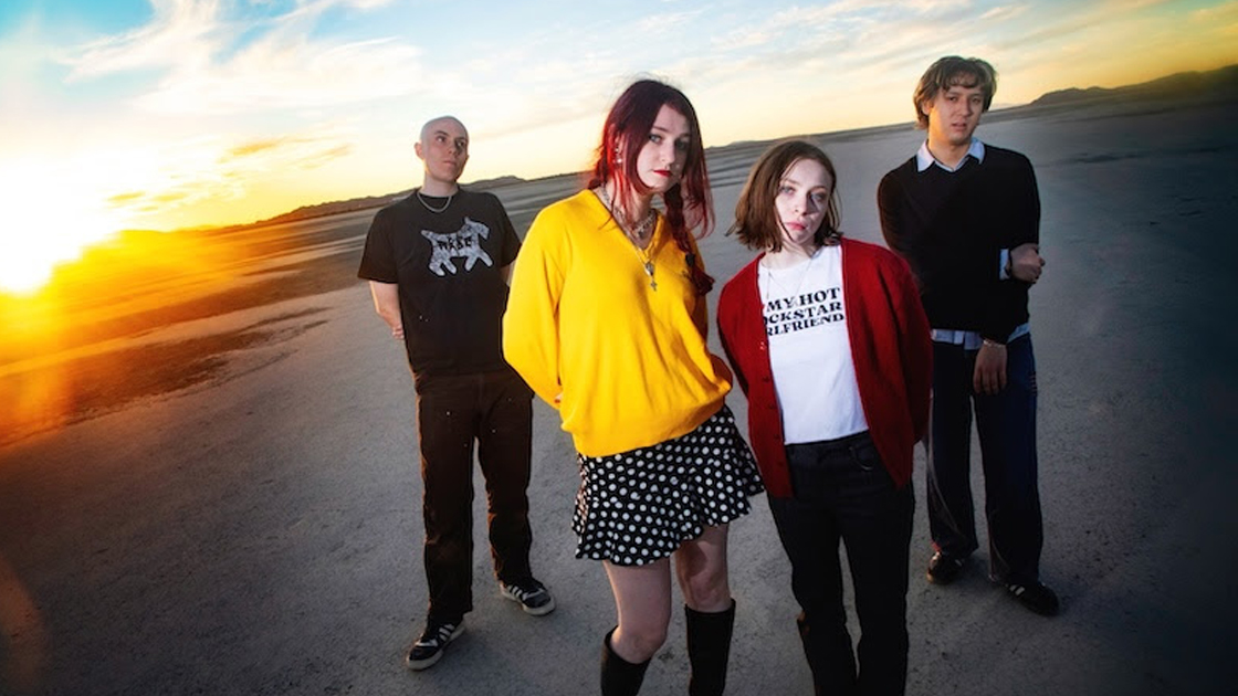 Four people photographed outside during sunset