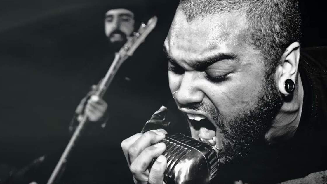 black and white photo of singer screaming into a microphone.