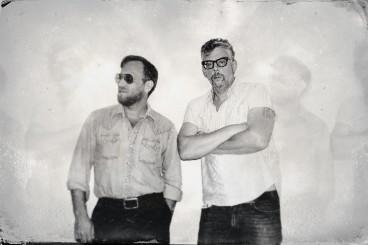 Black and white photograph of two men against white background