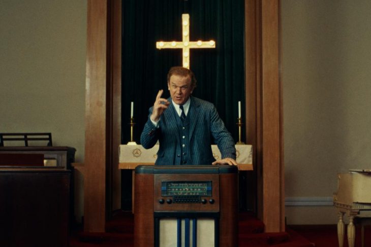 photo of preacher standing behind antique radio