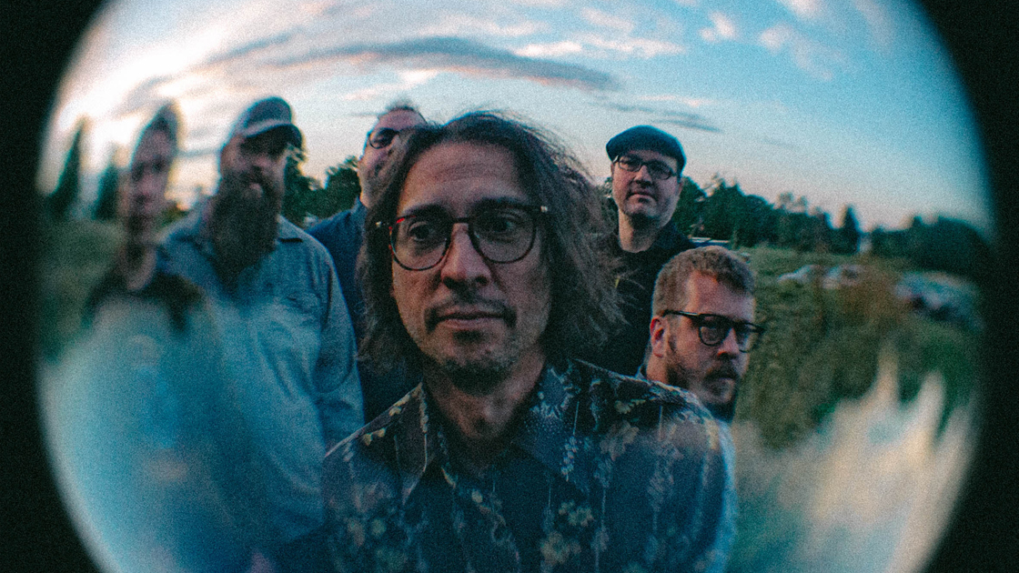 photo of 6 musicians taken in a field with fish eye lens.