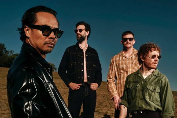 four men standing in the sun