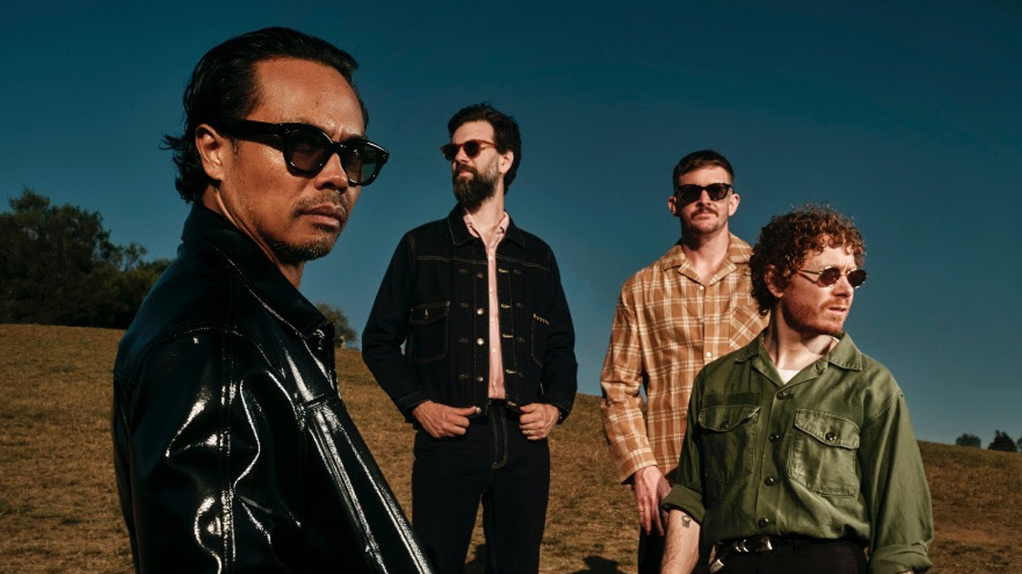 four men standing in the sun