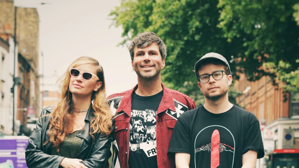 two men and one woman standing in the street