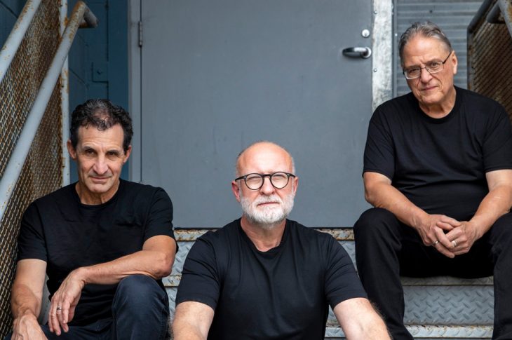 three men sitting on stairs