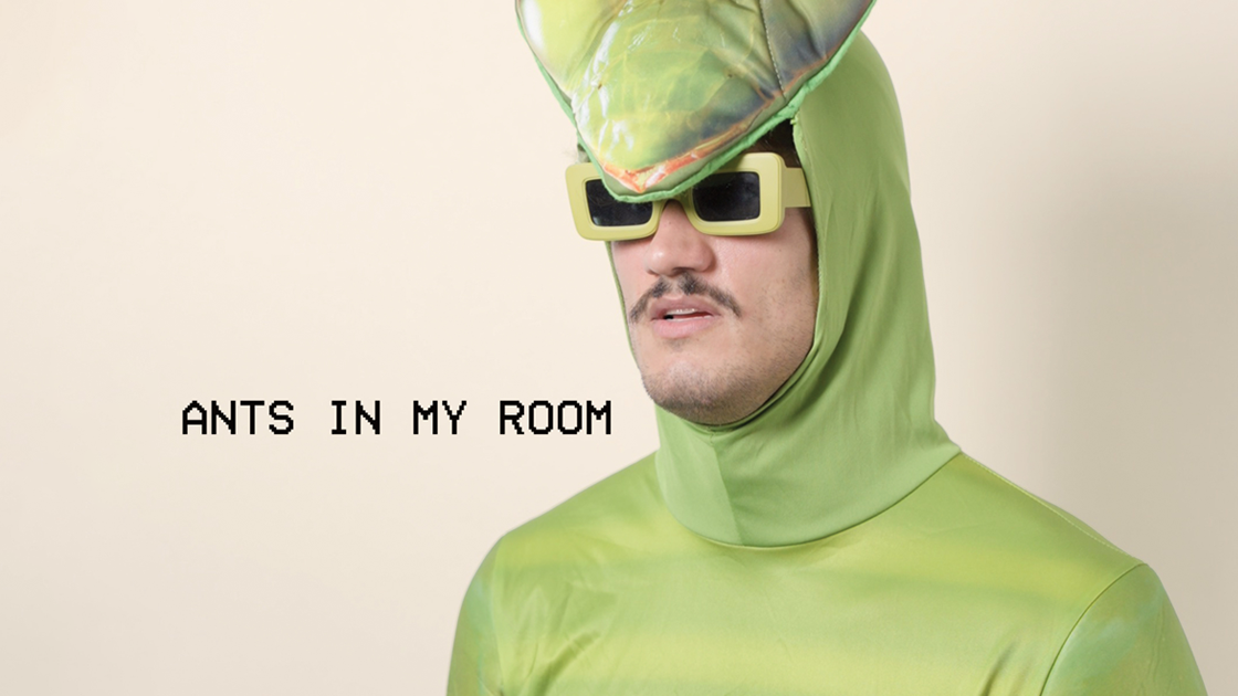 man wearing insect costume and sunglasses photographed against white background.