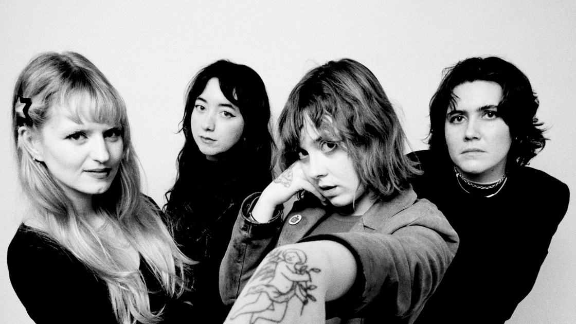 black and white photo of four people photographed against white backgroud