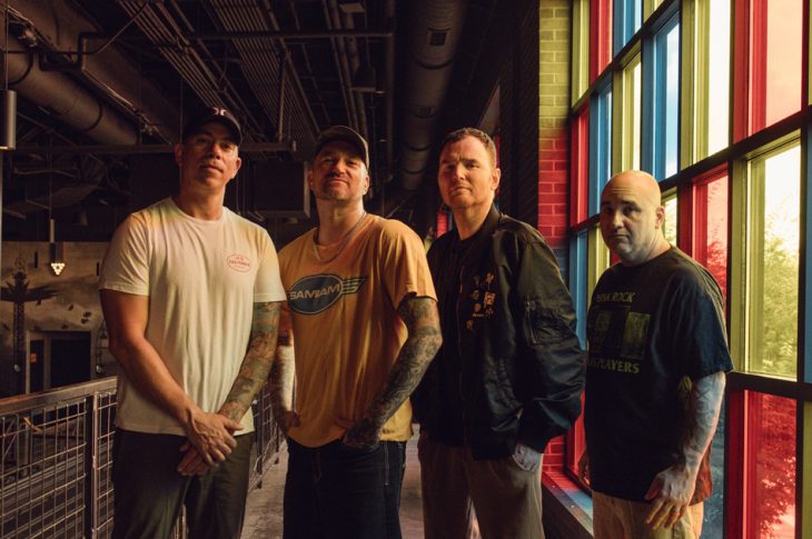 four men photographed in warehouse