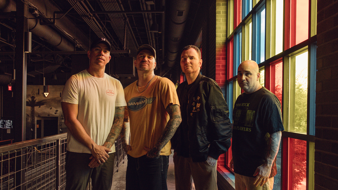 four men photographed in warehouse