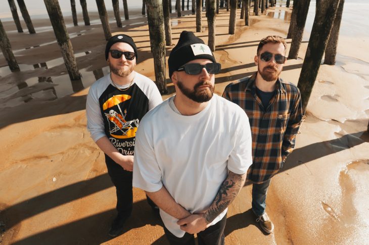 three men standing under pier