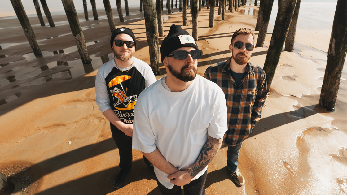 three men standing under pier