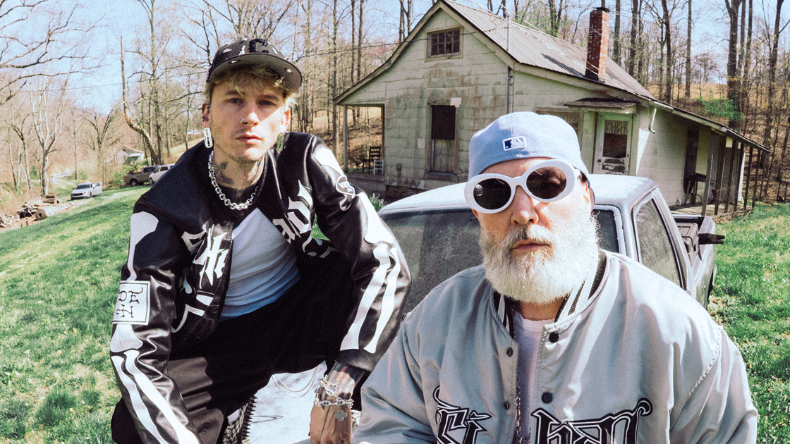 Two men sitting on hood of car
