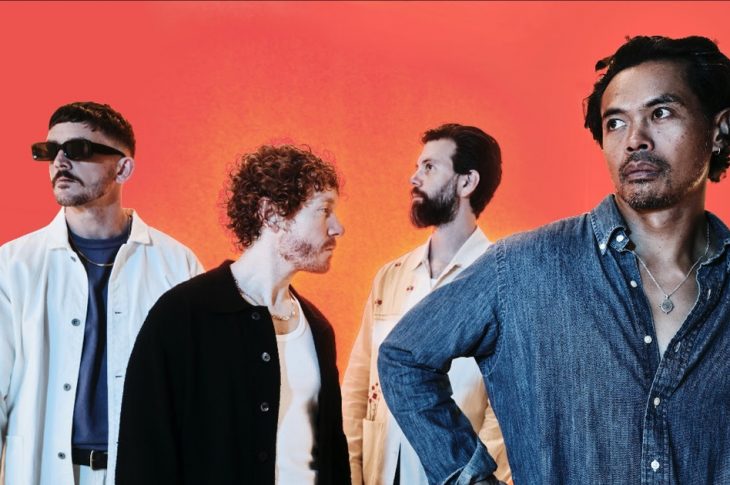 four men photographed against orange backdrop