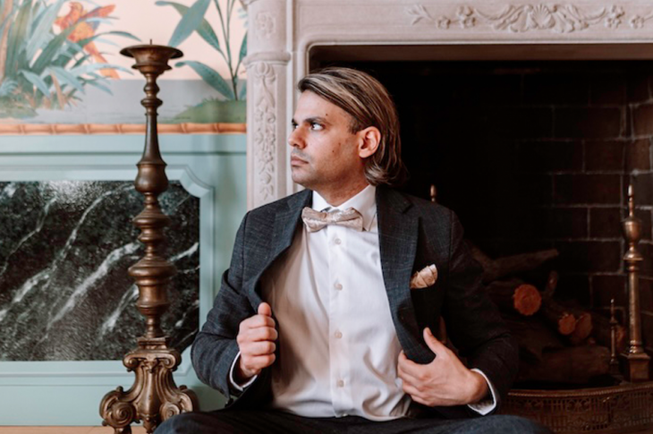 photo of man in suit sitting on the floor.