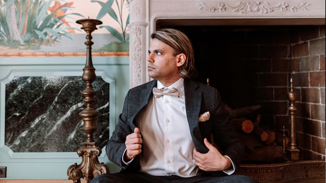 photo of man in suit sitting on the floor.
