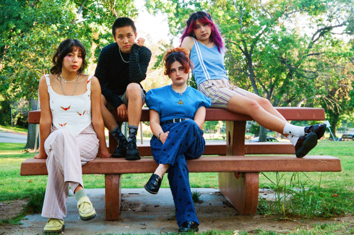 four people sitting on picnic table