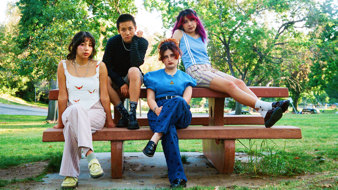 four people sitting on picnic table