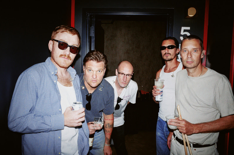 5 men photographed in hallway.