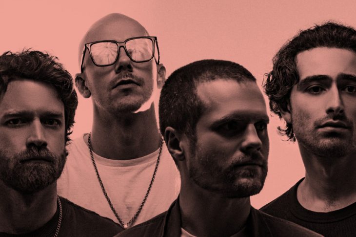 Pink-hued photo of four men
