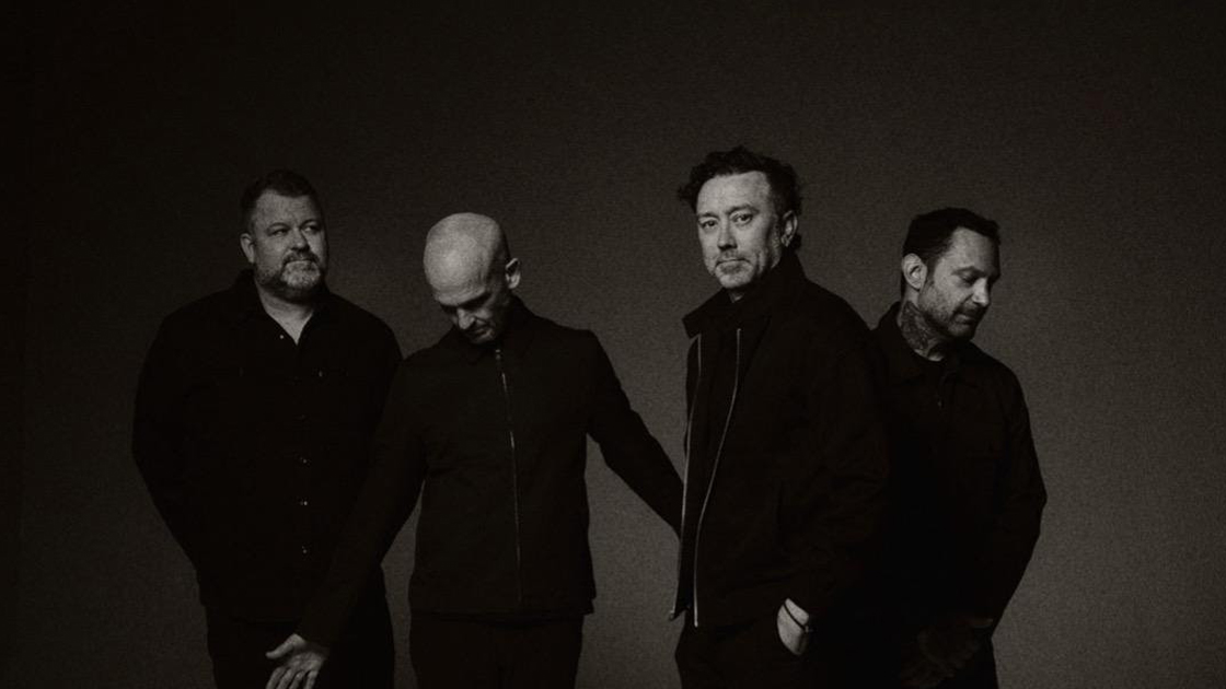 Black and white photo of 4 men in studio