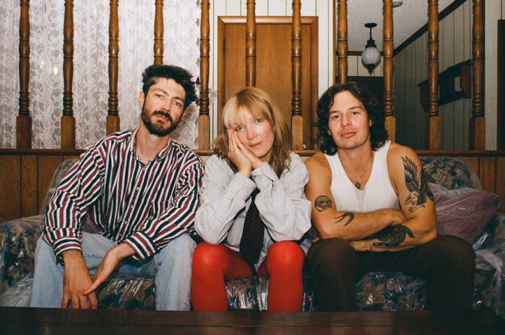 three people sitting on a couch
